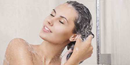 woman in shower washing hair with shampoo