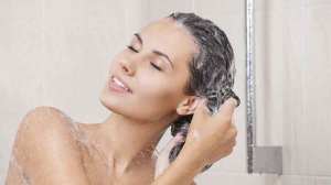 woman in shower washing hair with shampoo