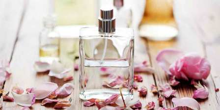perfume bottle surrounded by rose petals