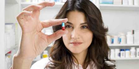 pharmacist holding a pill