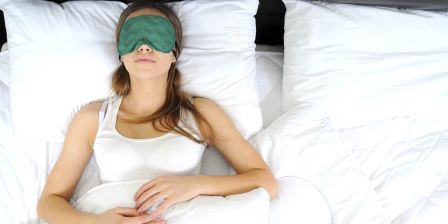woman sleeps with blindfod over her eyes