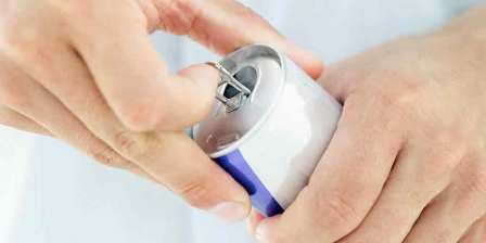 opening a can of red bull energy drink