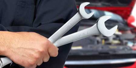 car mechanic holds spanners