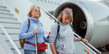 blind person and carer disembarking plane