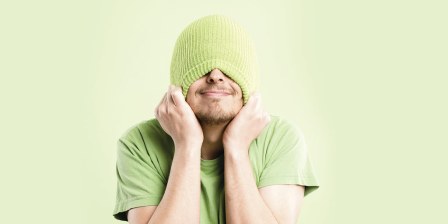 embarassed man pulling beanie over head