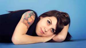 woman with tattoo on shoulder lying on floor