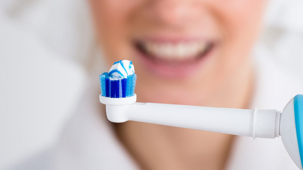 woman holding electric toothbrush
