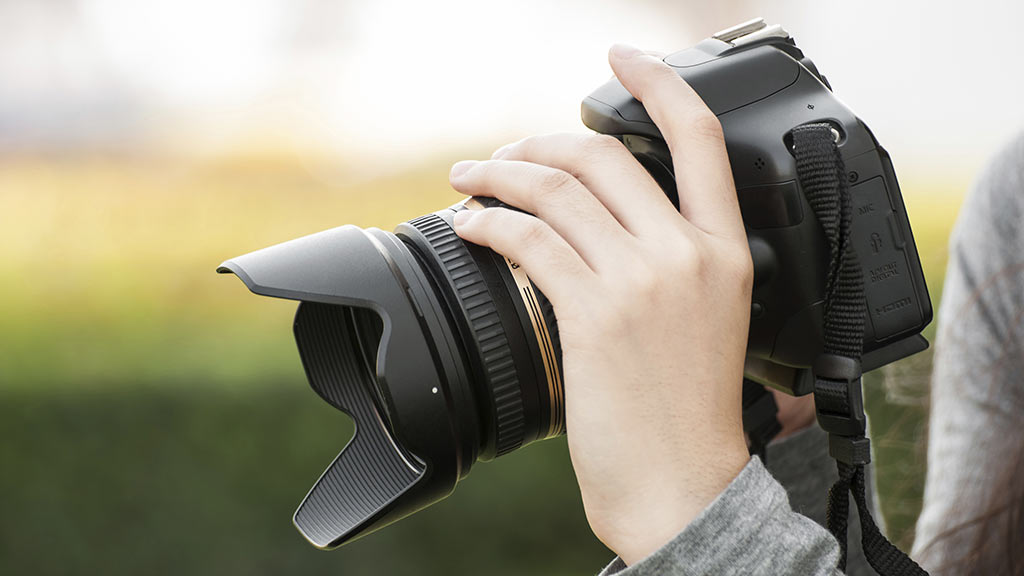 person holiding slr camera