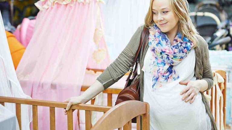 pregnant woman shopping for cot