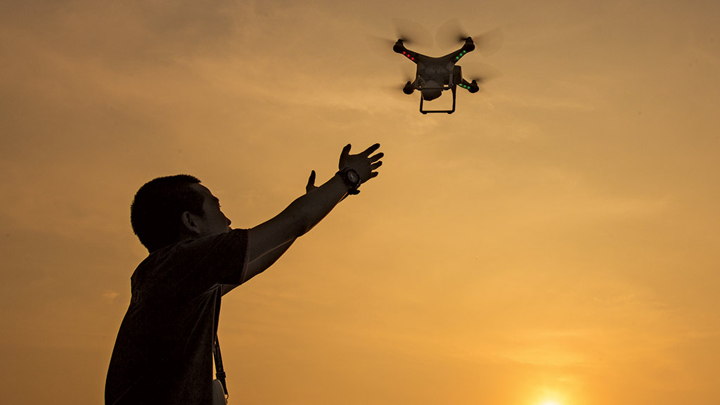 man releasing a drone into the air