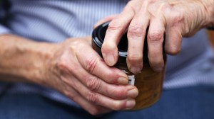 older person trying to open jar