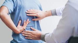 Person with back pain visiting a physiotherapist