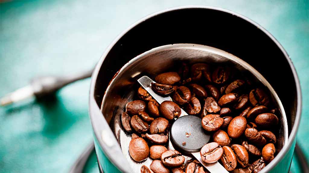 close up of coffee grinder with beans