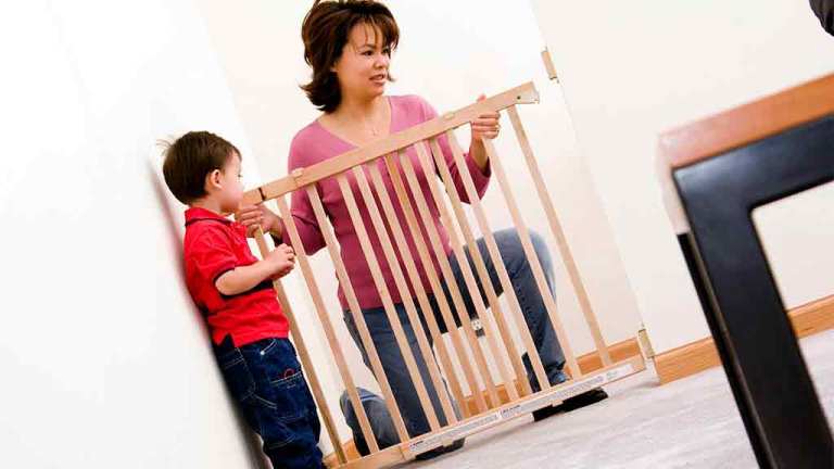 mother puts up safety gate for child