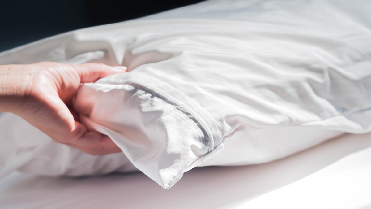hand testing firmness of bed pillow