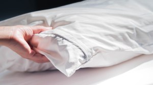 hand testing firmness of bed pillow