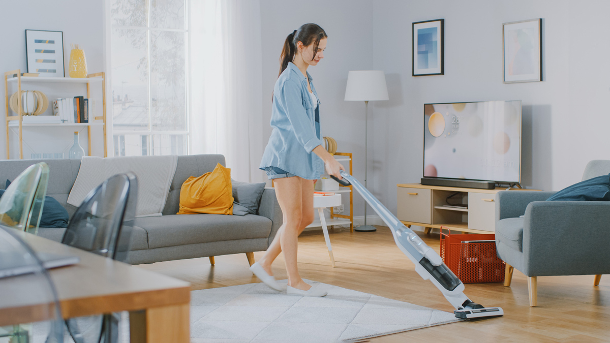 woman using a stick vac at home lead