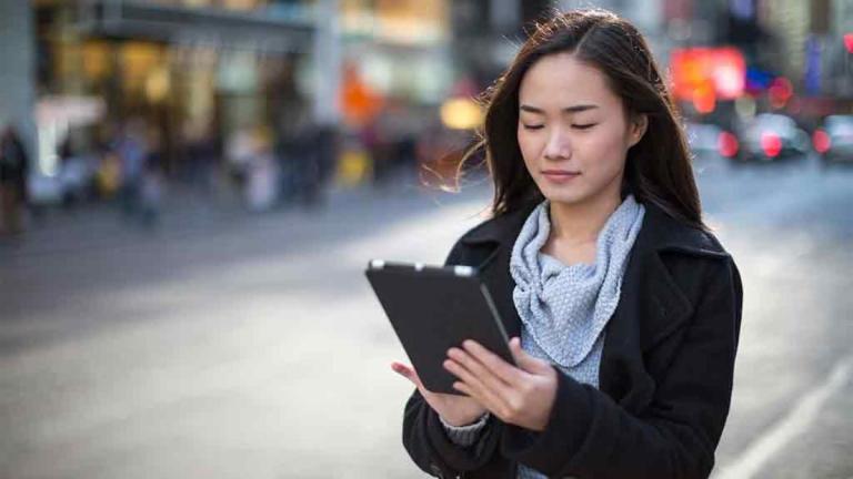 woman reads ebook in street