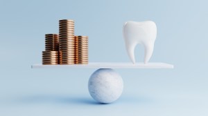 a scale showing piles of coins balanced next to a tooth