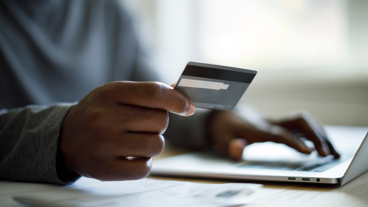 first_nations_person_on_laptop_holding_credit_card