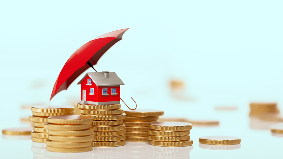 toy_house_on_stacks_of_coins_protected_by_an_umbrella