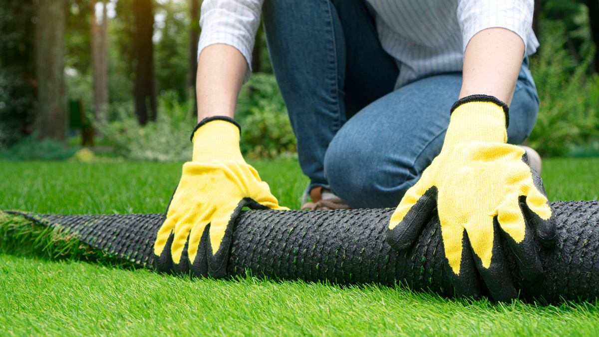 person removing fake grass