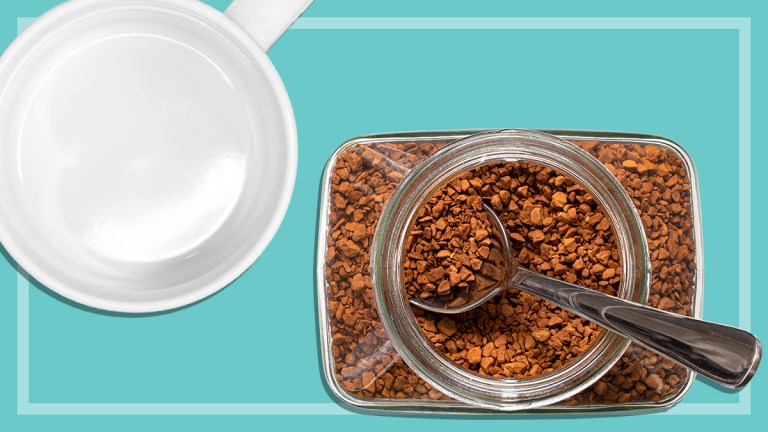 jar of instant coffee with spoon and empty coffee mug