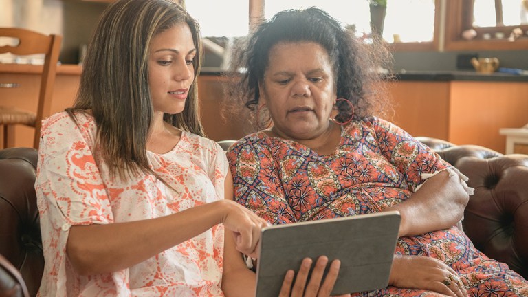 daughter helping mother with ombudsman on tablet