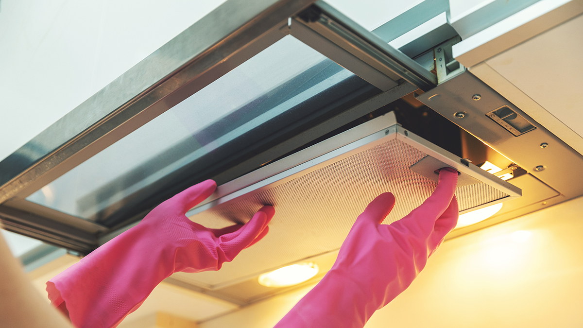 person removing the filter from a rangehood