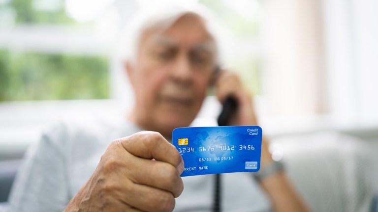 man_on_phone_reading_out_credit_card_number