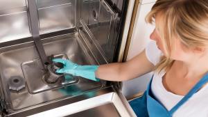 woman removing filter from dishwasher
