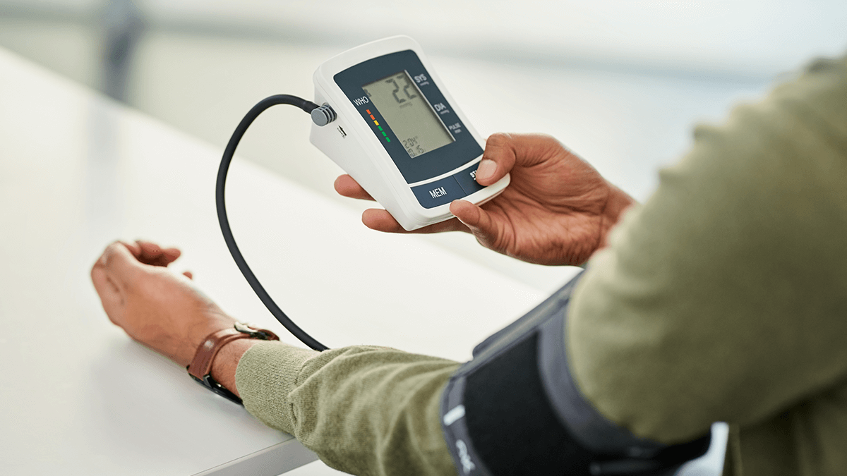 person checking their blood pressure with a blood pressure monitor