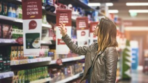 person checking specials in supermarket aisle