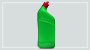 green bottle of toilet cleaner on a grey background