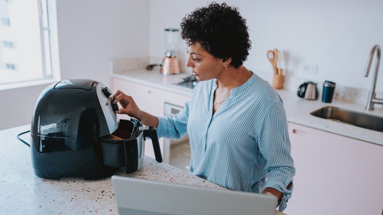 woman looking up tips on laptop for air frying