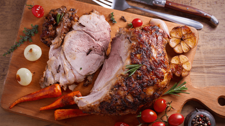 glazed christmas ham being sliced on a wooden board