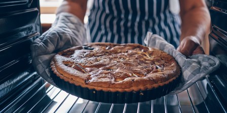 person taking fig tart out of the oven