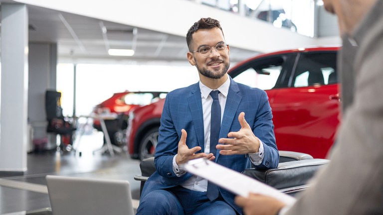 salesperson discussing contract with car buyer