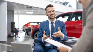 salesperson discussing contract with car buyer