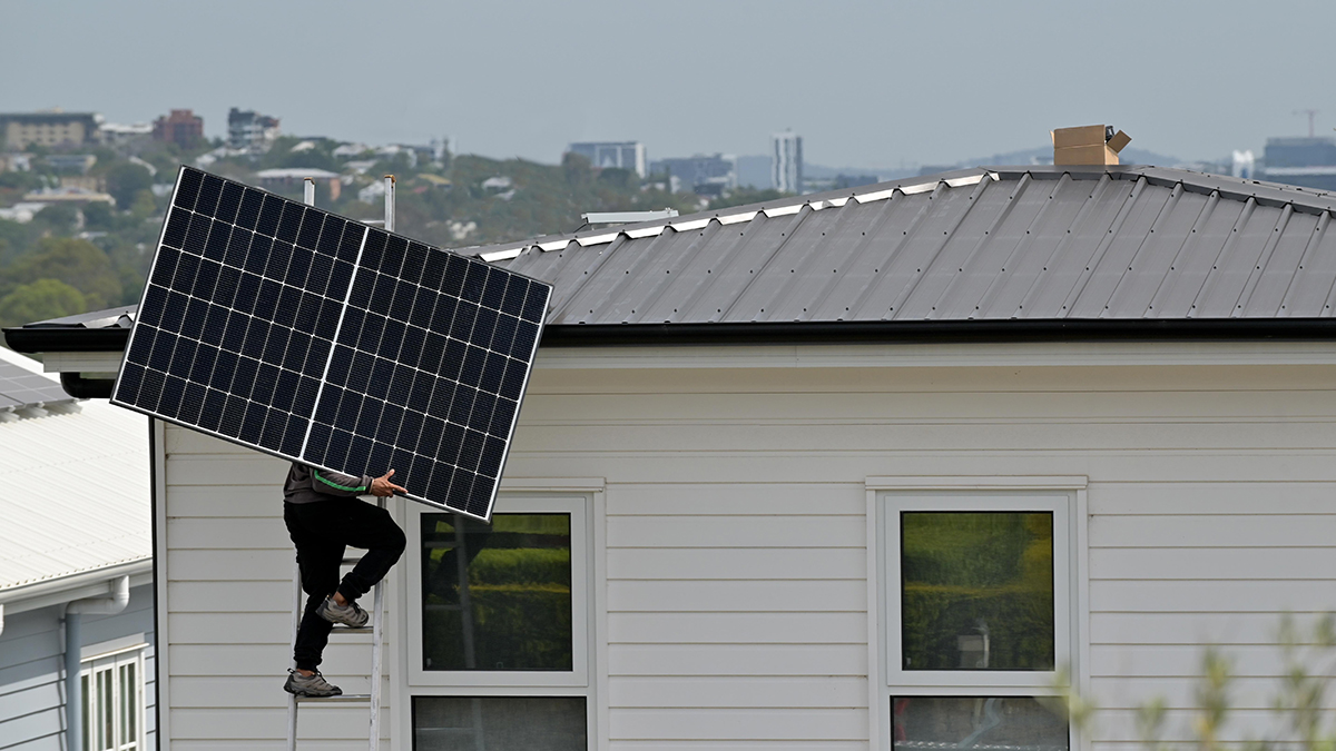 solar panel tradesman climbing ladder onto australian roof with solar panel
