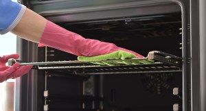 person cleaning oven