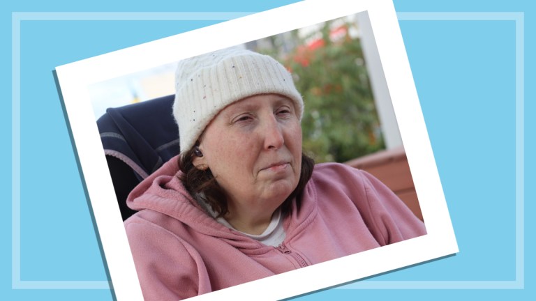 photo of heather lewis sitting outside on blue background