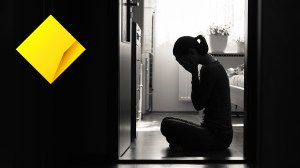 upset woman on bedroom floor and commonwealth bank logo