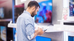 man looking at prices shopping for a tv