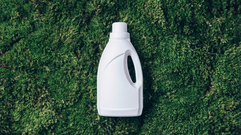 white laundry detergent bottle on green foliage